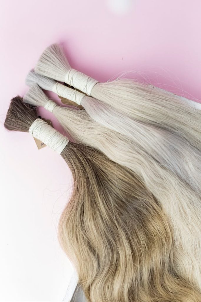 The Art of Drawing Readers In: Your attractive post title goes here Close-up view of diverse human hair extensions on a soft pink surface.